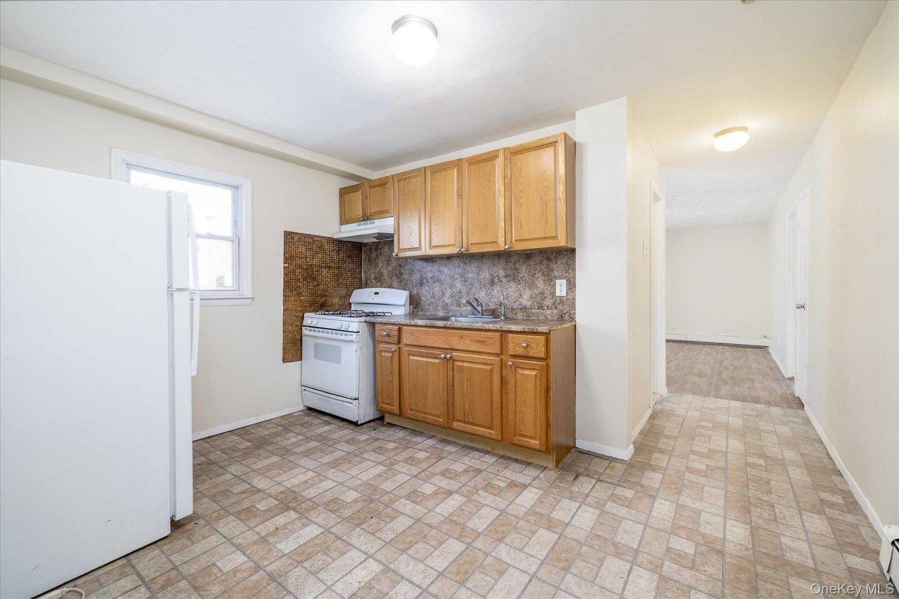 143 Wellington Road Elmont, NY 11003 - Photo 12 of 24 a kitchen with a refrigerator sink and cabinets