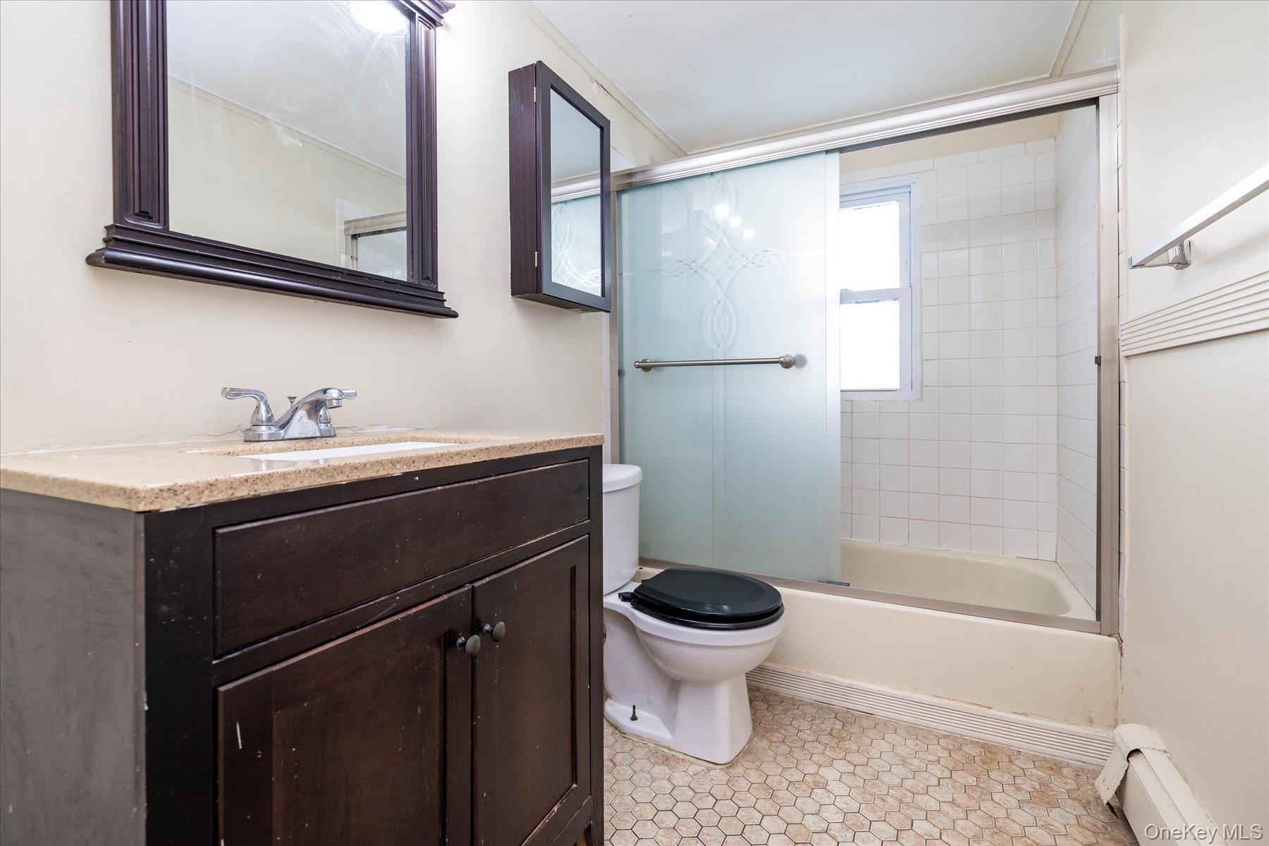 143 Wellington Road Elmont, NY 11003 - Photo 13 of 24 a bathroom with a sink toilet a mirror and shower