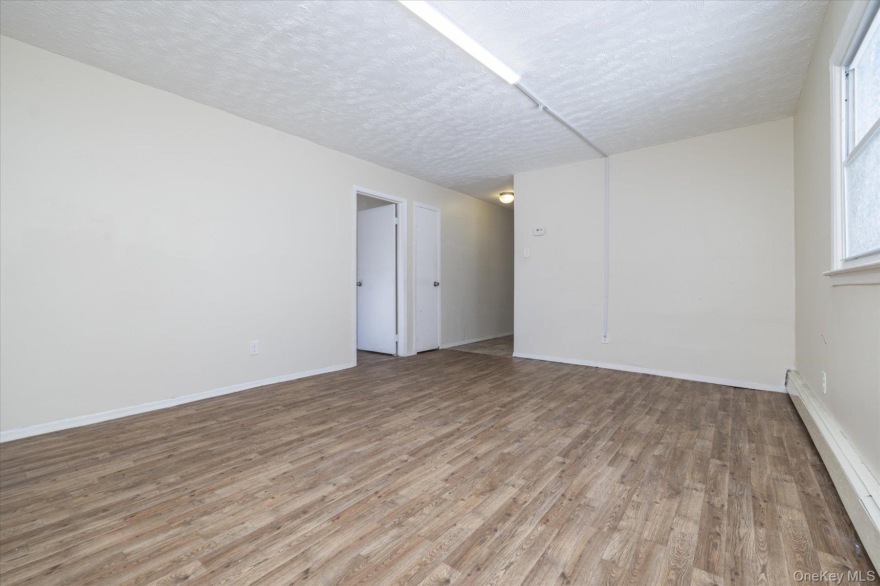 143 Wellington Road Elmont, NY 11003 - Photo 15 of 24 a view of an empty room and wooden floor