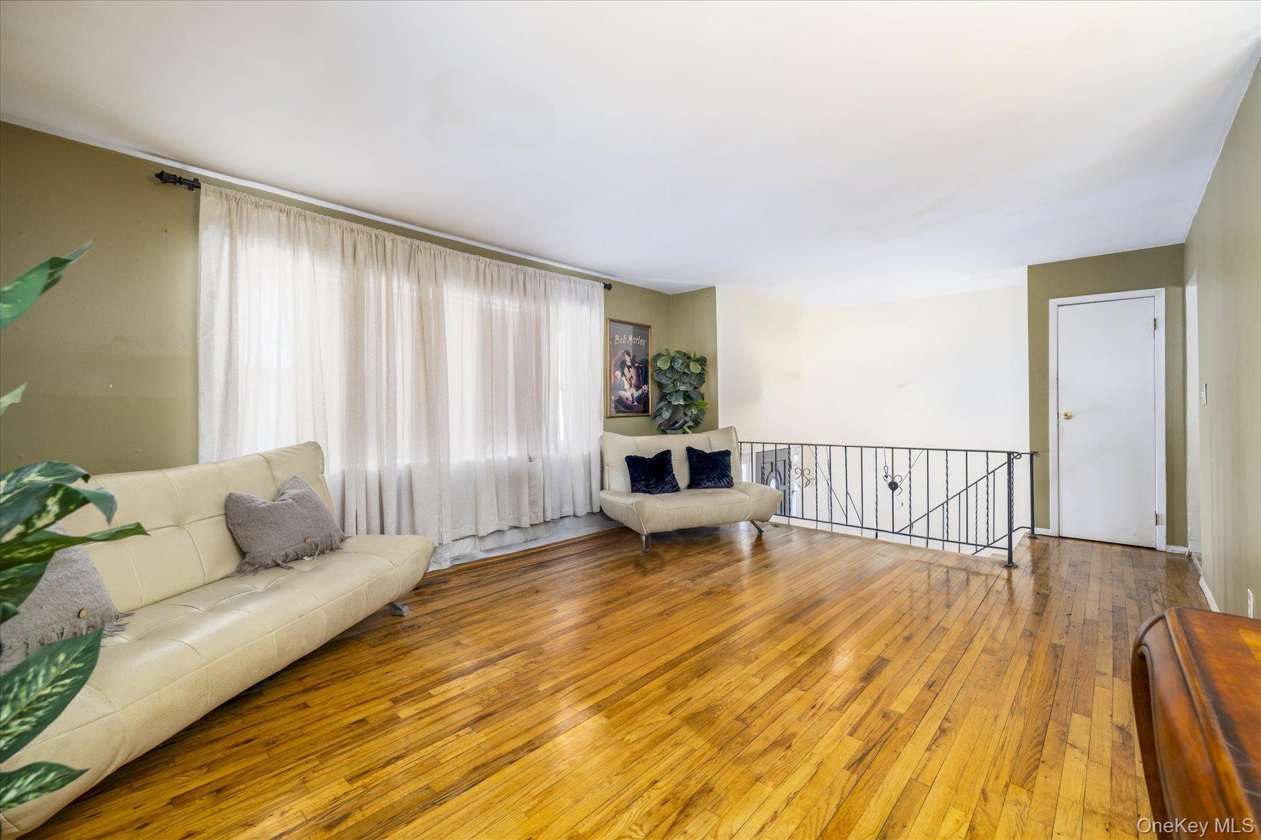 143 Wellington Road Elmont, NY 11003 - Photo 2 of 24 a living room with furniture and wooden floor