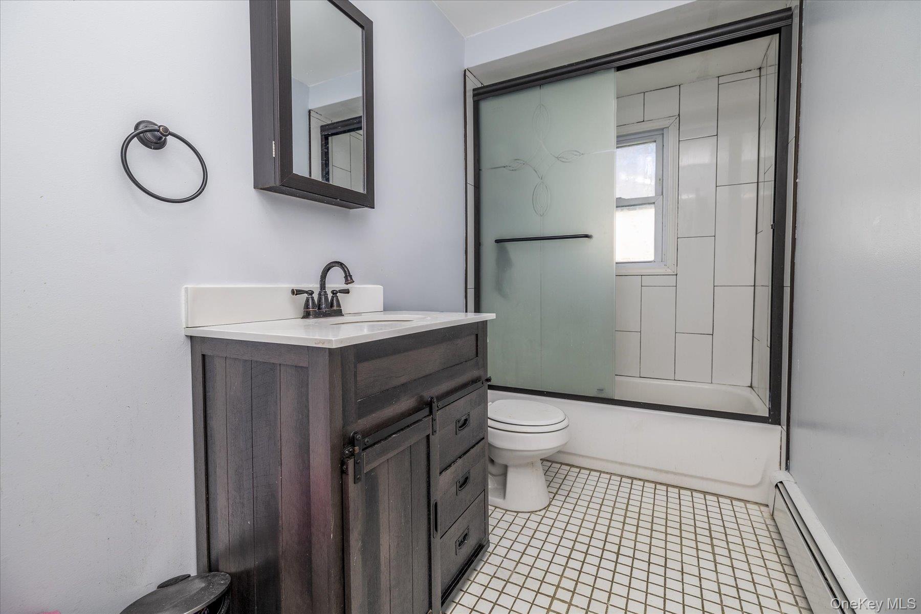 143 Wellington Road Elmont, NY 11003 - Photo 7 of 24 a bathroom with a sink a toilet and a mirror