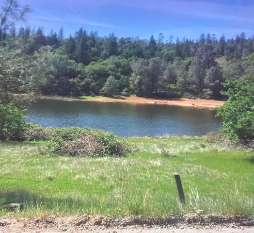 an aerial view of a houses with a yard and lake view