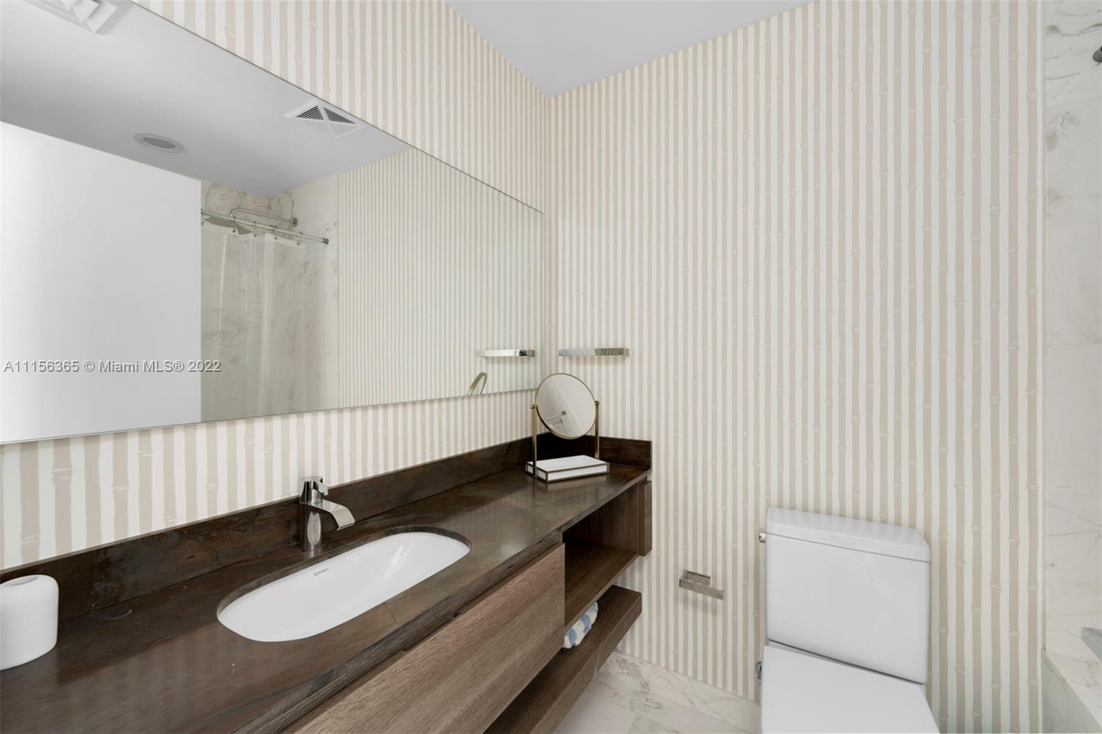 360 Ocean Drive, Unit 1101S Key Biscayne, FL 33149 - Photo 32 of 65 a bathroom with a granite countertop sink and a mirror