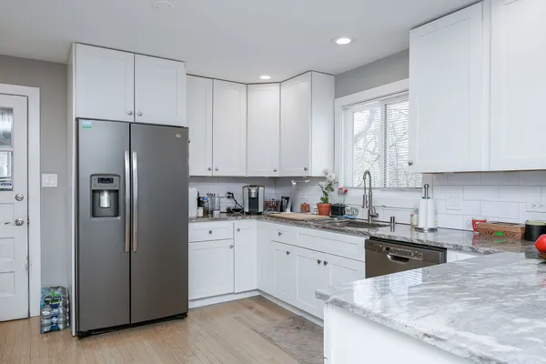 a kitchen with stainless steel appliances granite countertop a refrigerator sink and cabinets