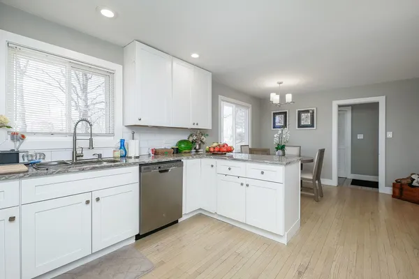 a kitchen with white cabinets appliances and a sink