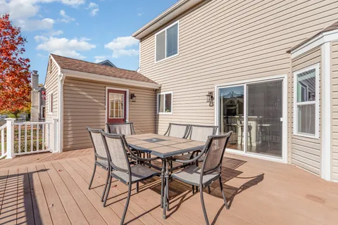 a patio with table and chairs and potted plants