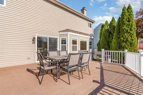 a view of a house with wooden deck and outdoor seating