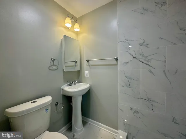a bathroom with a sink toilet and a mirror