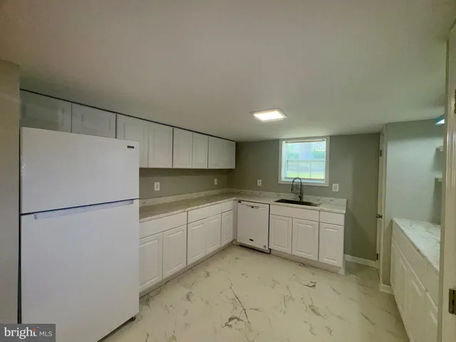 a kitchen with sink cabinets and refrigerator
