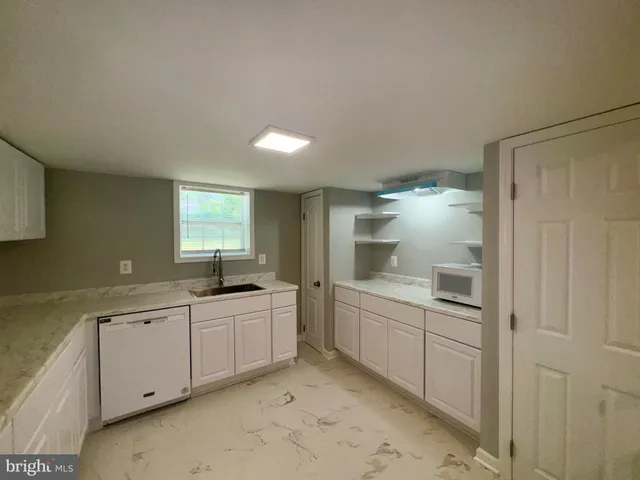 a room with white cabinets and sink