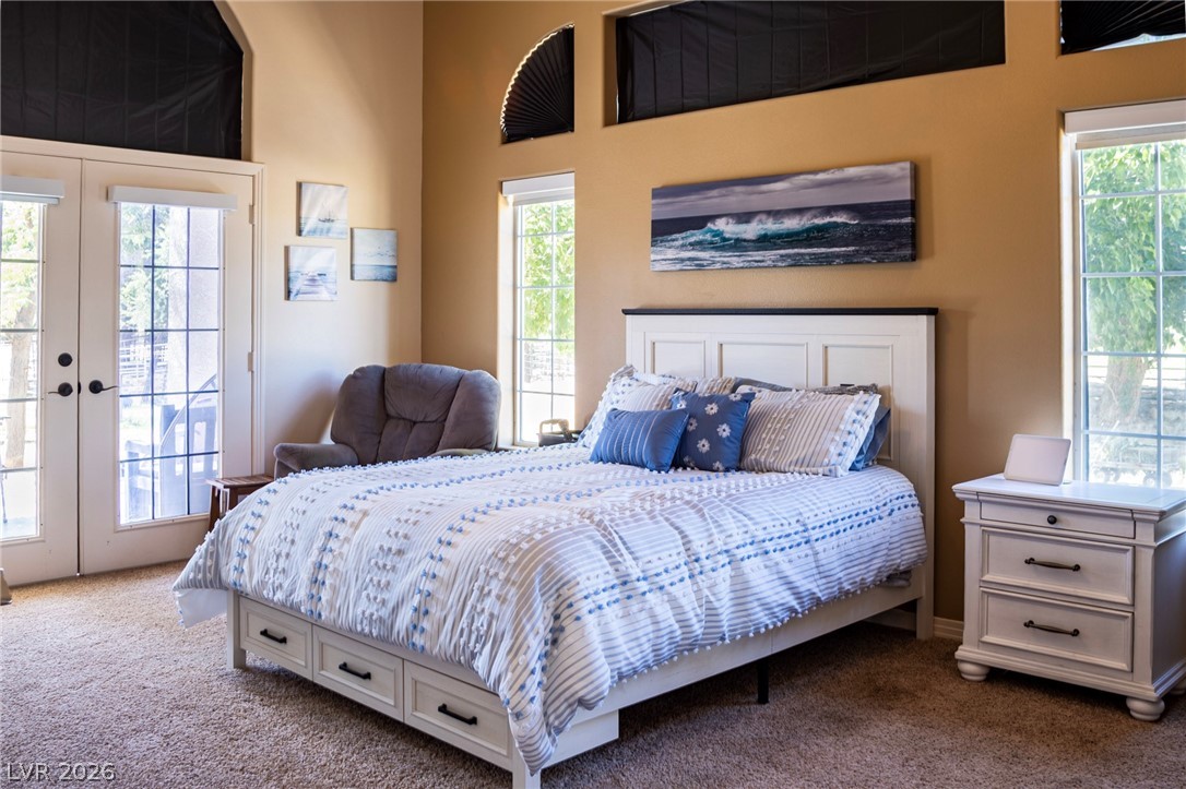 2775 Taylor Street Logandale, NV 89021 - Photo 4 of 41 This inviting bedroom offers plush carpeting and ample natural light through large windows and a glass-paneled door.