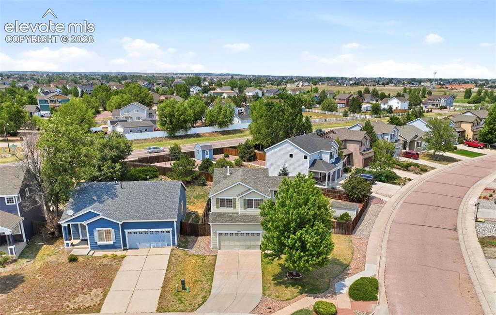 7904 Coffee Road Peyton, CO 80831 - Photo 45 of 48 Suburban streetscape featuring a curved brick-patterned road