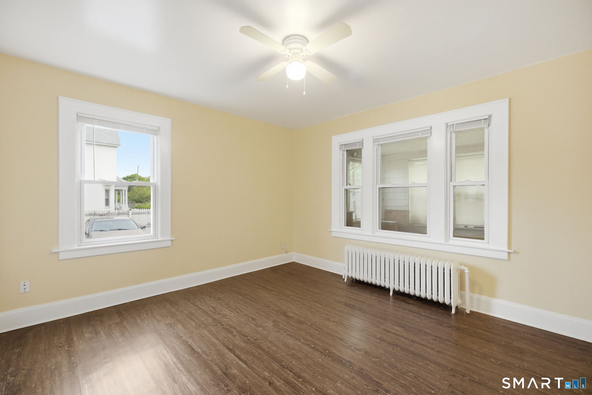 76 Harold Street Hartford, CT 06112 - Photo 3 of 12 an empty room with wooden floor and windows