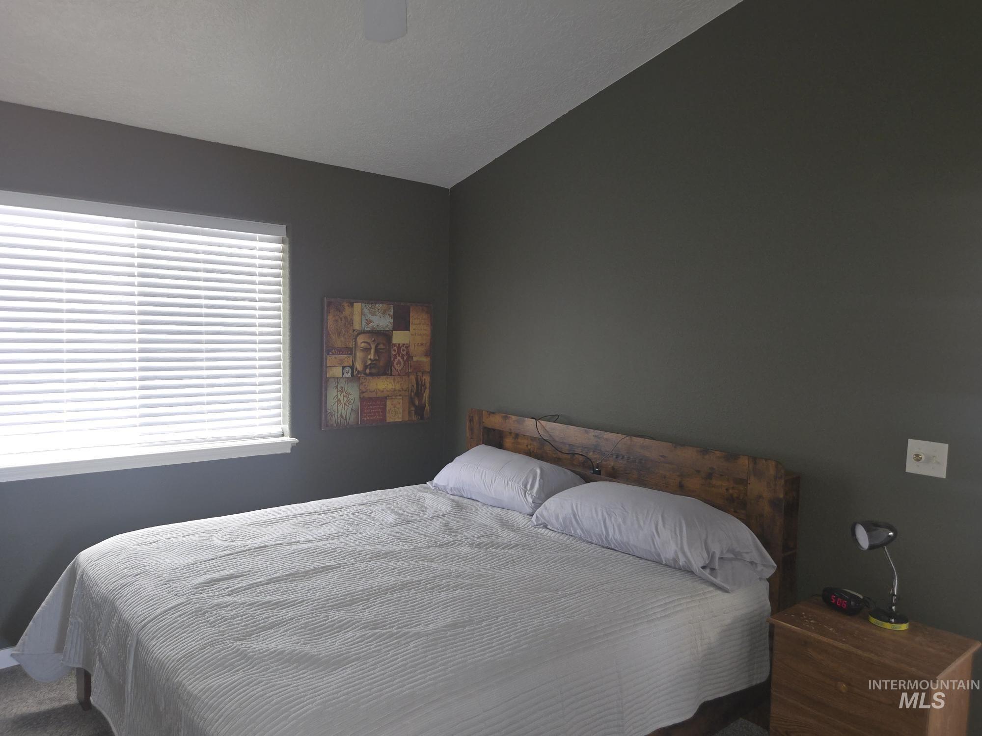 2480 West 9th Street Weiser, ID 83672 - Photo 12 of 17 Bedroom with a vaulted ceiling, neutral wall tones, and a window with horizontal blinds
