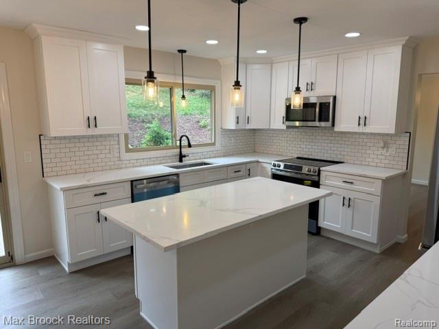 650 Deerfield Court Rochester, MI 48309 - Photo 5 of 28 Gourmet kitchen featuring white shaker cabinetry, white quartz countertops, and a large center island with waterfall edge