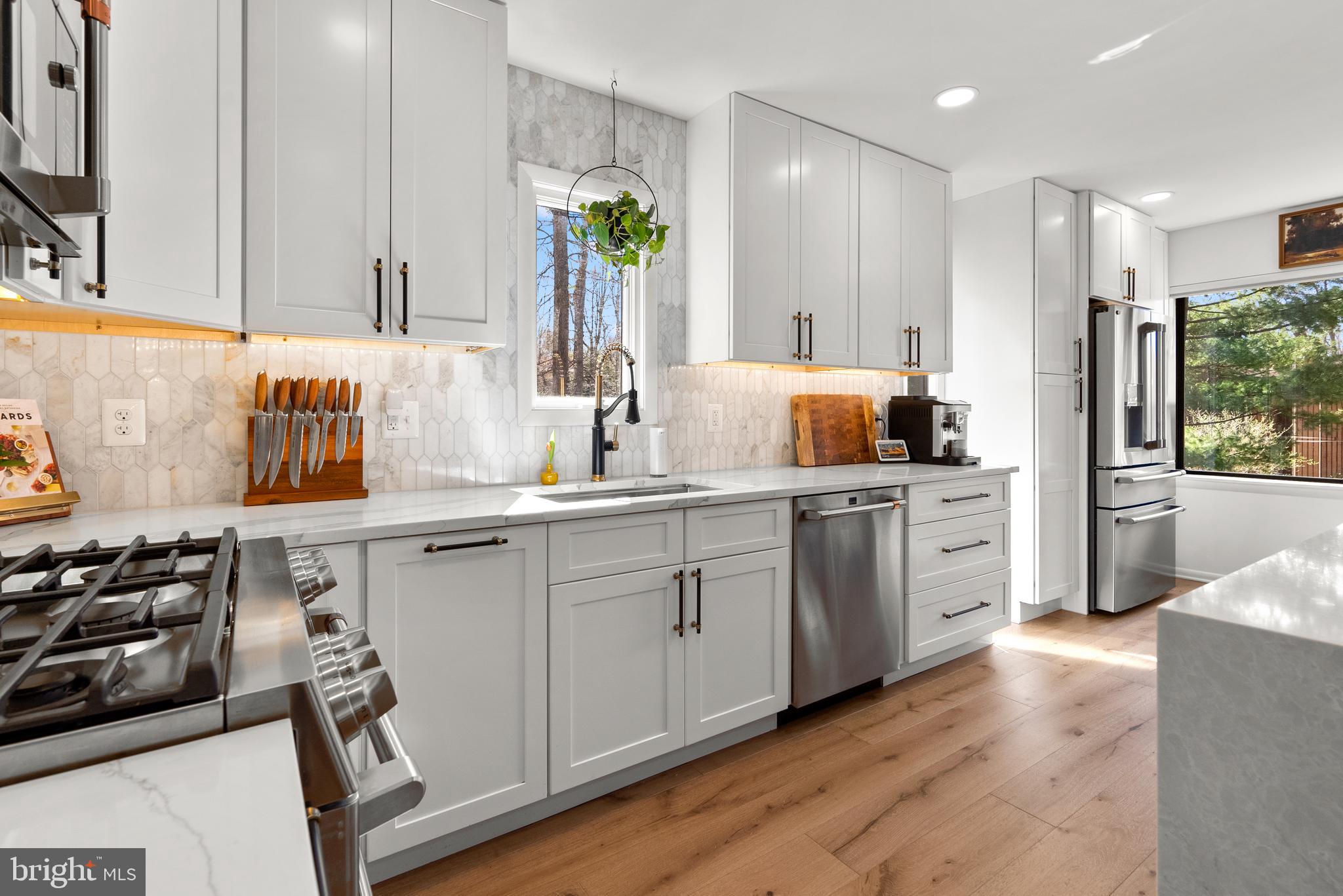 5213 Bradfield Drive Burke, VA 22015 - Photo 7 of 48 a kitchen with stainless steel appliances a sink stove and cabinets