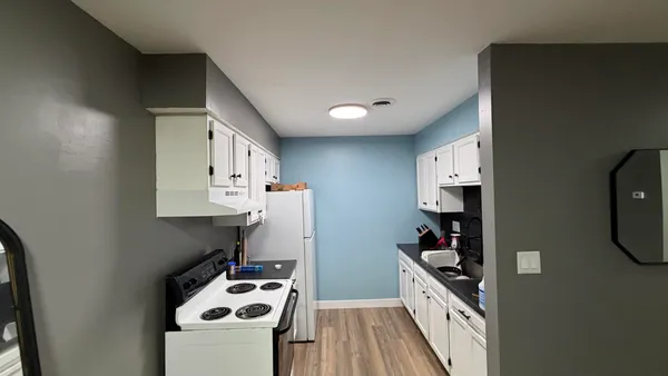 a kitchen with stainless steel appliances a white stove top oven a sink and a refrigerator