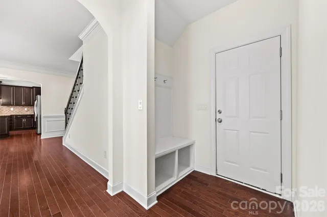 a view of a hallway with wooden floor and staircase