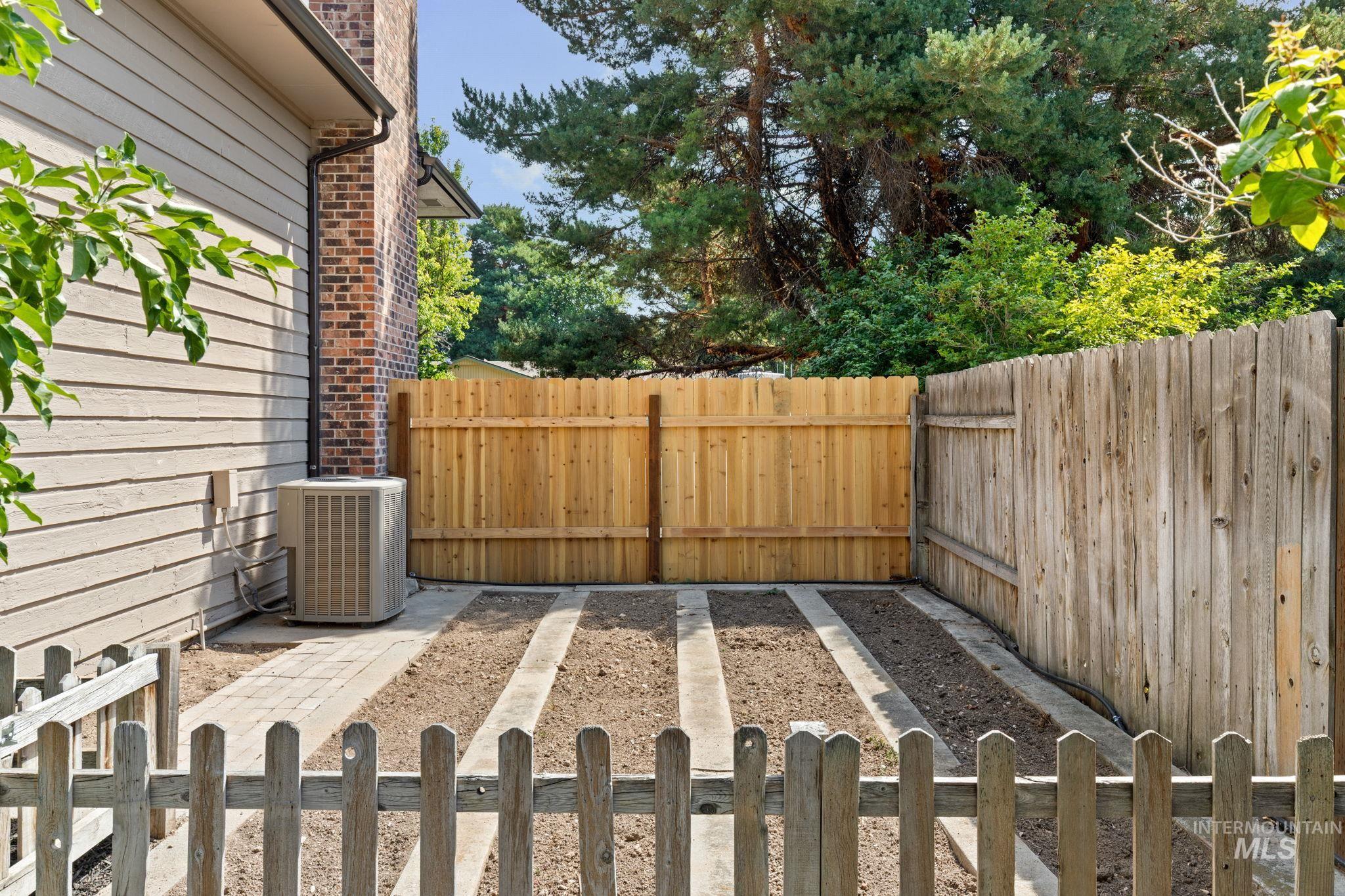 1675 Country Terrace Way Meridian, ID 83642 - Photo 45 of 50 Defined garden beds with paver borders, complemented by a new wood fence and older wood fence