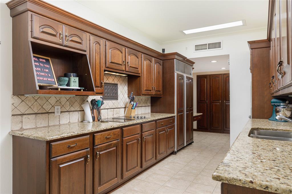 6126 Averill Way, Unit 103W Dallas, TX 75225 - Photo 13 of 34 a kitchen with stainless steel appliances granite countertop a sink stove and refrigerator