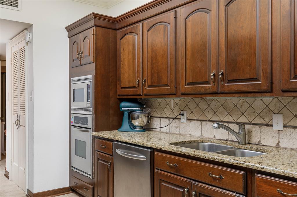6126 Averill Way, Unit 103W Dallas, TX 75225 - Photo 14 of 34 a kitchen with stainless steel appliances granite countertop a sink a refrigerator and cabinets