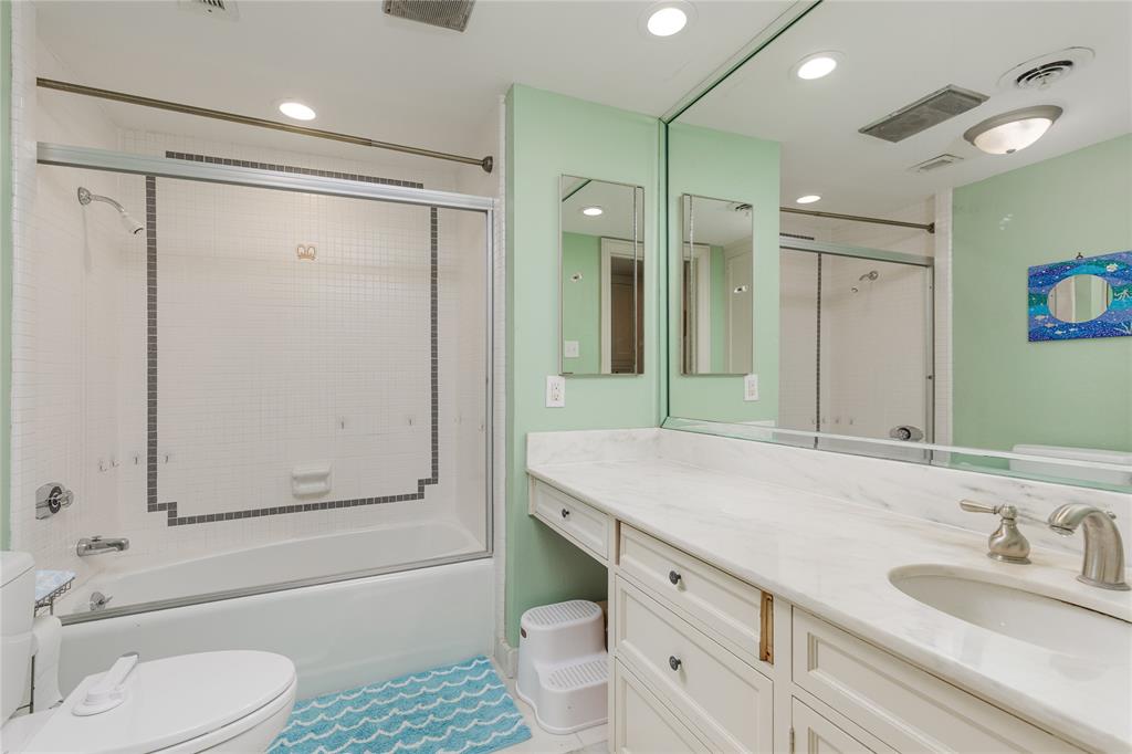 6126 Averill Way, Unit 103W Dallas, TX 75225 - Photo 20 of 34 a bathroom with a granite countertop sink toilet and shower