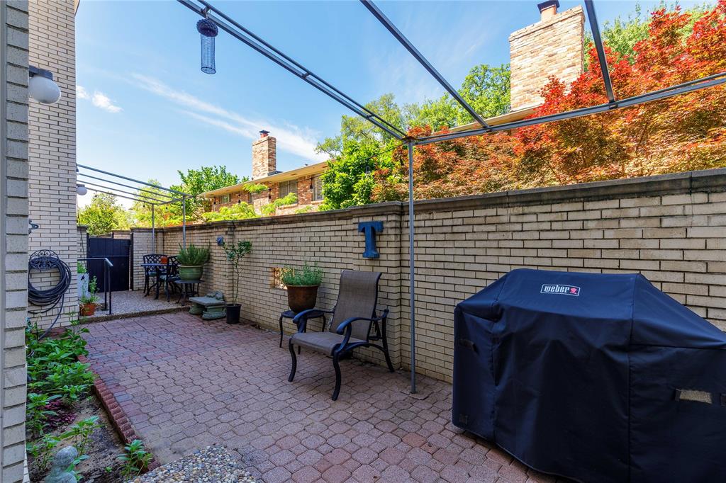 6126 Averill Way, Unit 103W Dallas, TX 75225 - Photo 23 of 34 a backyard of a house with table and chairs