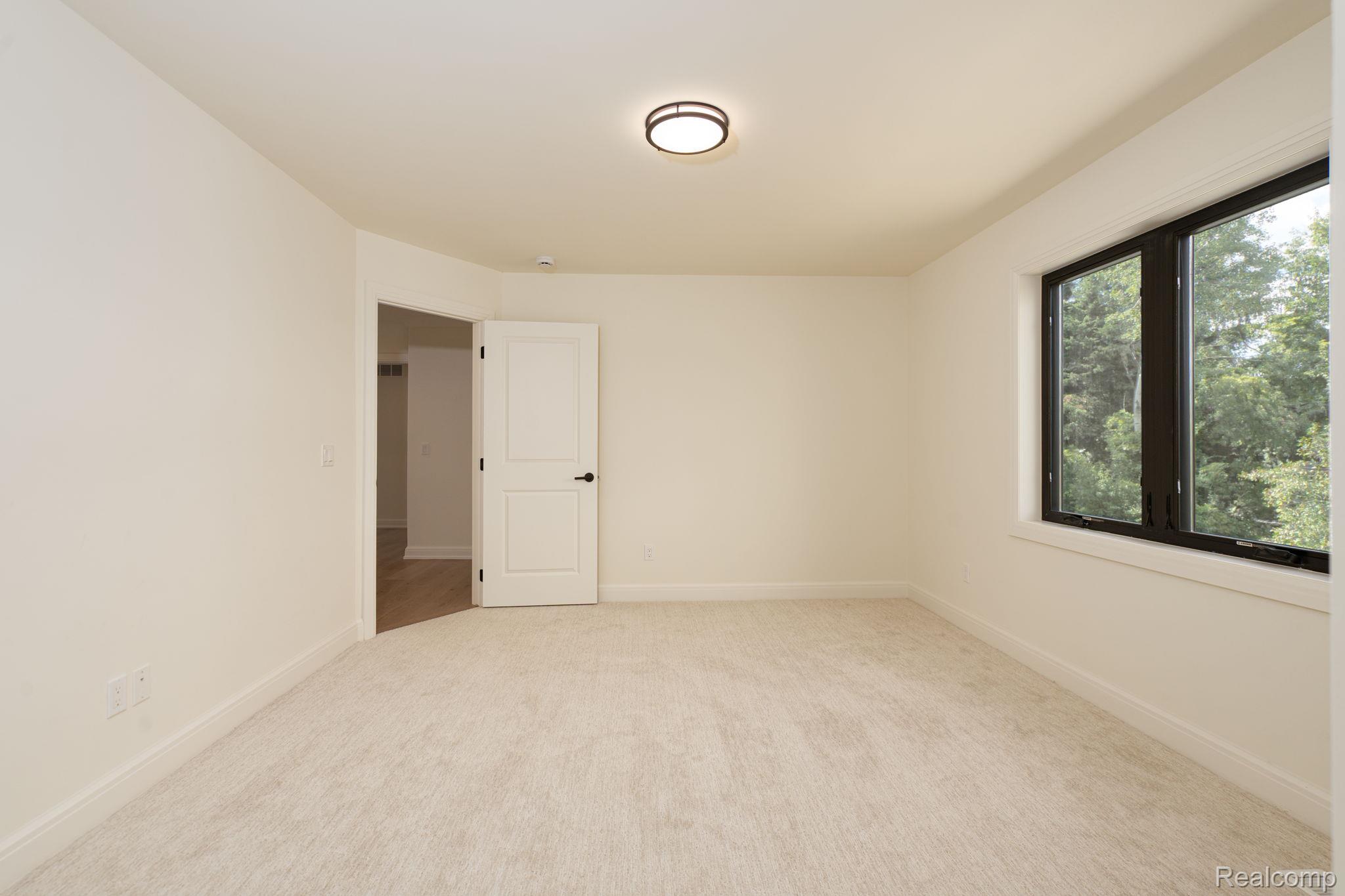 3836 Coachwood Lane Rochester, MI 48309 - Photo 57 of 82 Neutral tone walls with light-toned carpet flooring and a black-framed window