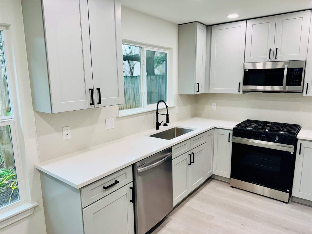 5013 Cana Cove, Unit B Austin, TX 78749 - Photo 11 of 25 a kitchen with stainless steel appliances granite countertop a sink stove and microwave