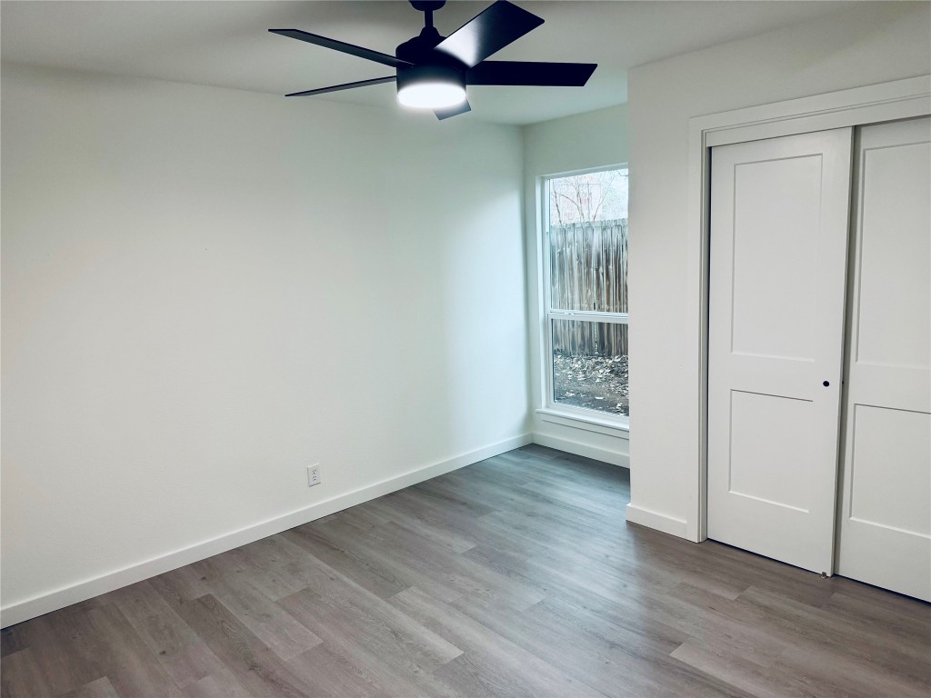 5013 Cana Cove, Unit B Austin, TX 78749 - Photo 19 of 25 an empty room with wooden floor fan and windows