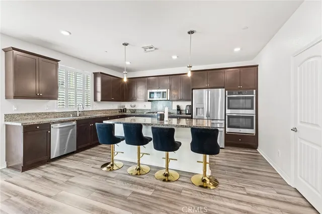 a kitchen with stainless steel appliances kitchen island granite countertop a stove and a refrigerator
