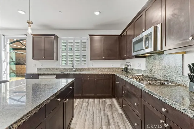 a kitchen with stainless steel appliances granite countertop a sink stove and cabinets