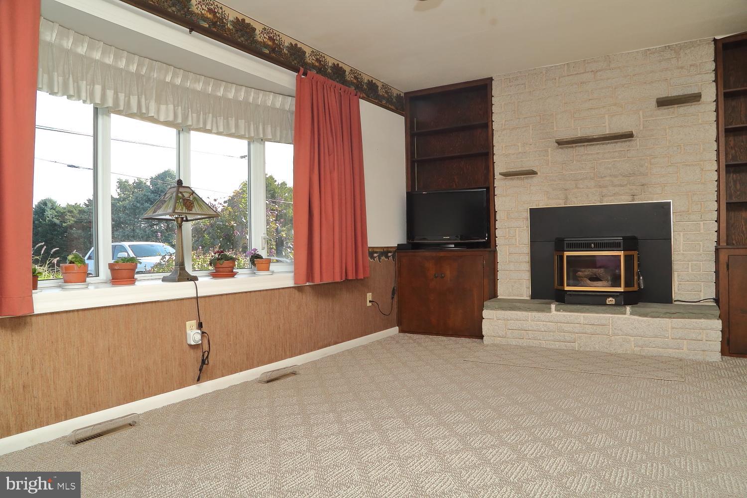 543 Hossler Road Manheim, PA 17545 - Photo 3 of 26 a living room with a fireplace and a floor to ceiling window