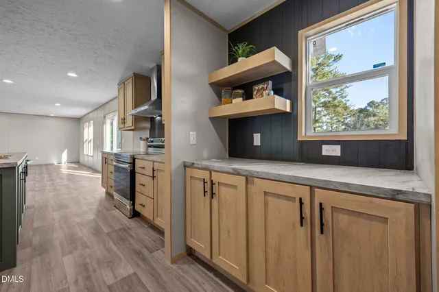 a kitchen with stainless steel appliances granite countertop a refrigerator and a wooden floors