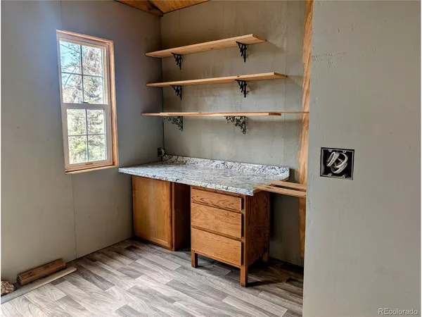 a view of a room with wooden floor and windows