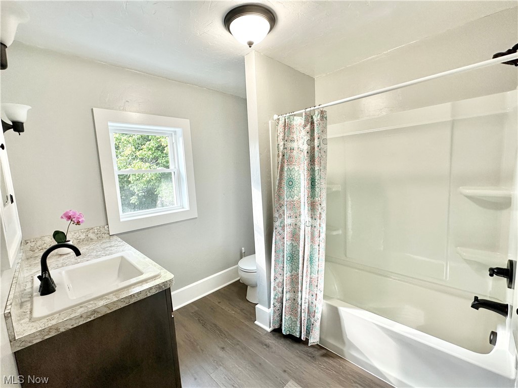 1140 Berwin Street Akron, OH 44310 - Photo 14 of 22 Full bathroom featuring shower / bath combo with shower curtain, vanity, and wood laminate flooring