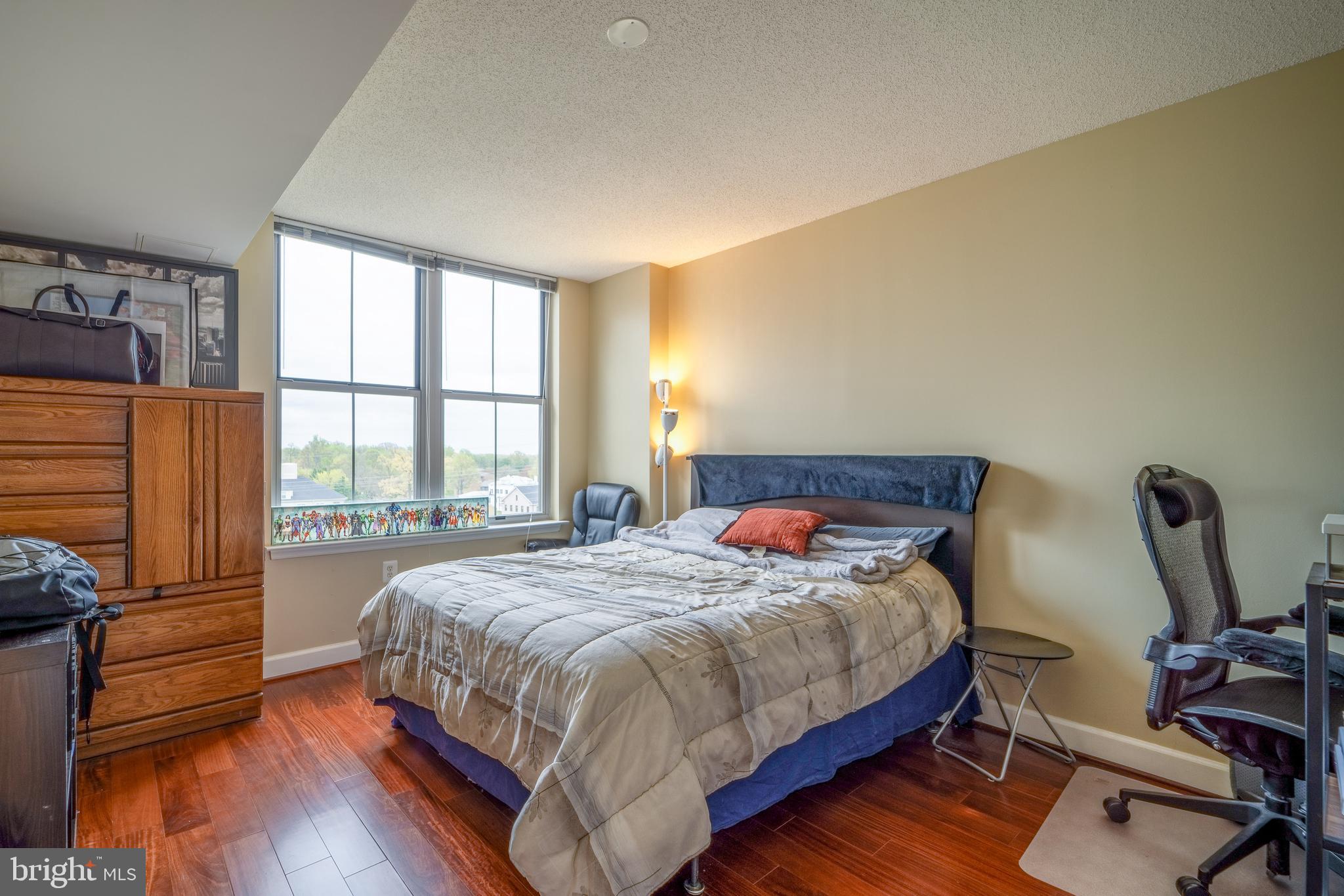 11800 Sunset Hills Road, Unit 925 Reston, VA 20190 - Photo 20 of 49 a bedroom with a bed a flat screen tv and wooden floor