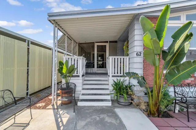 a porch with chairs and potted plant