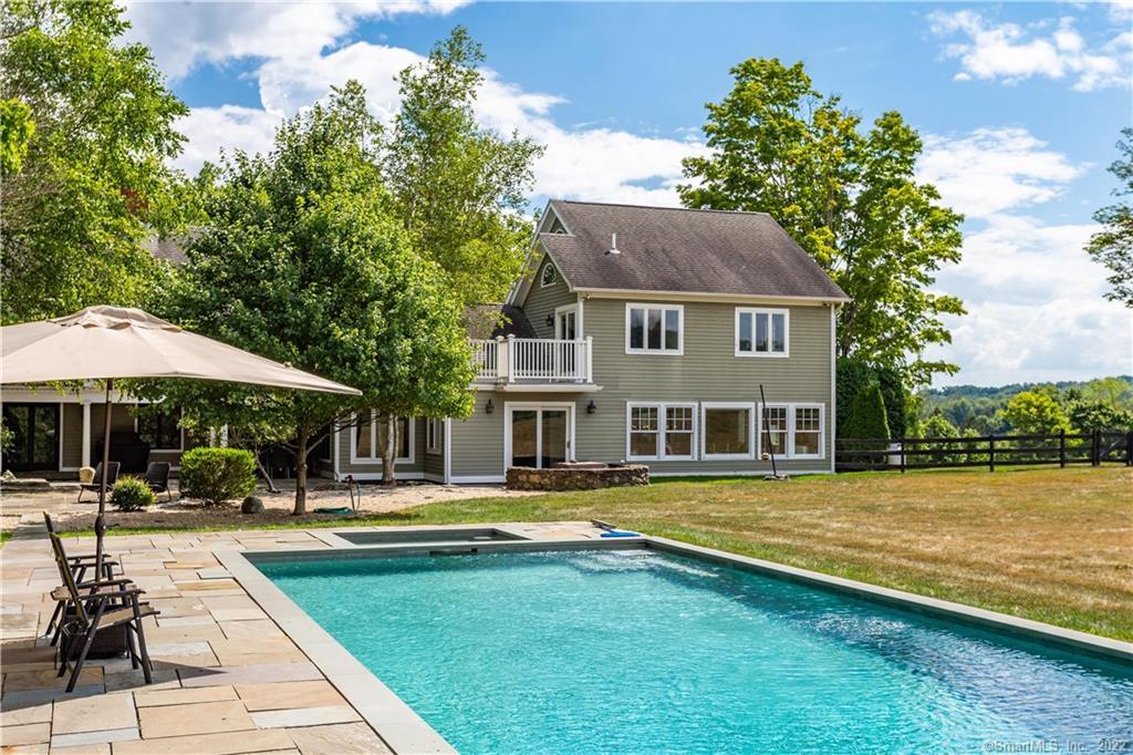 a view of a swimming pool with lawn chairs under an umbrella
