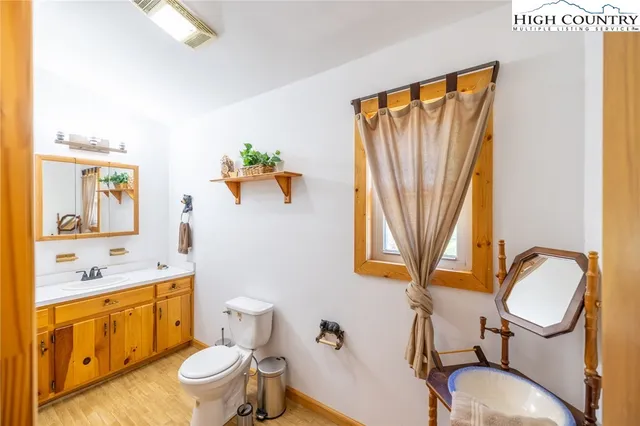 a bathroom with a sink mirror vanity and toilet