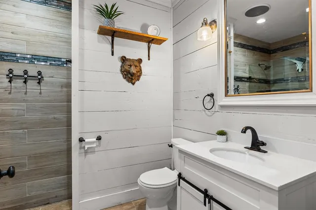 a bathroom with a sink mirror toilet and shower