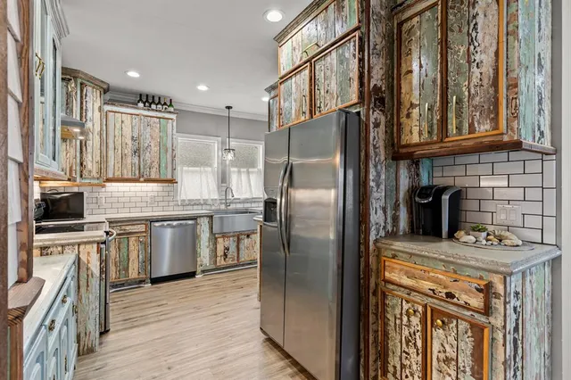 a kitchen with stainless steel appliances granite countertop a refrigerator a stove and a sink