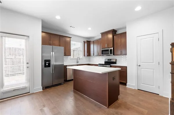 a kitchen with stainless steel appliances granite countertop a stove a sink and a refrigerator