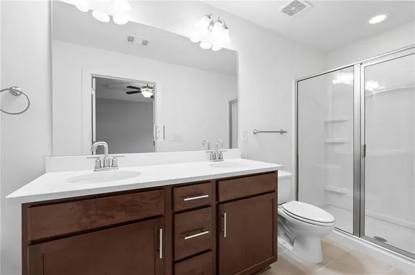 a bathroom with a toilet a sink a mirror and a shower