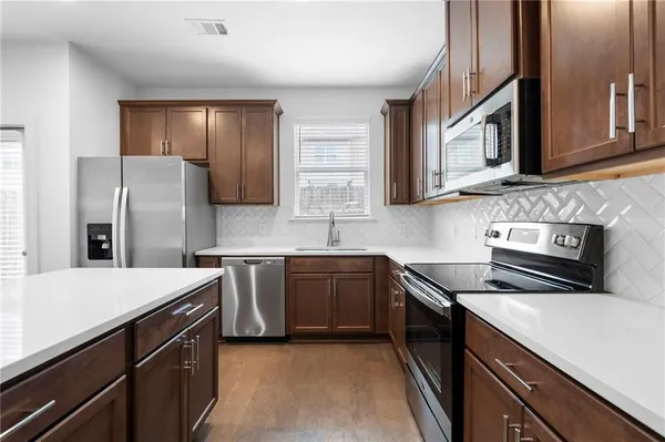 a kitchen with stainless steel appliances a sink stove and refrigerator
