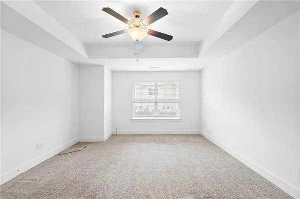 an empty room with a window and a fan