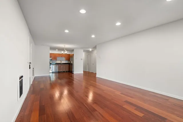 a view of empty room with wooden floor