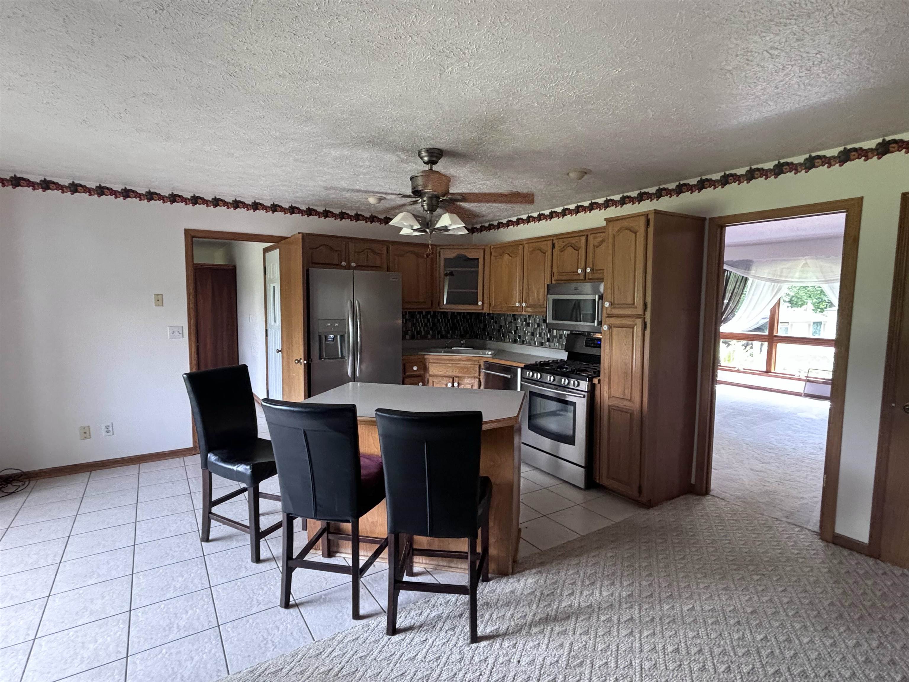 3543 Mill Road Cherry Valley, IL 61016 - Photo 5 of 46 a kitchen with stainless steel appliances granite countertop a refrigerator a sink dishwasher a stove and a dining table with wooden floor