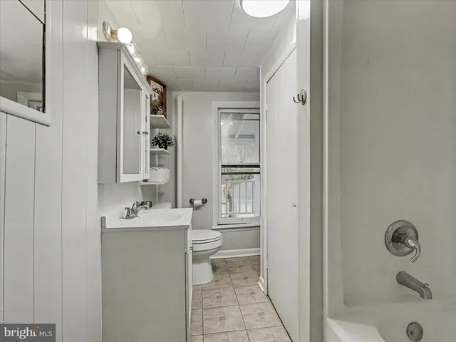 a bathroom with a granite countertop sink mirror vanity and toilet