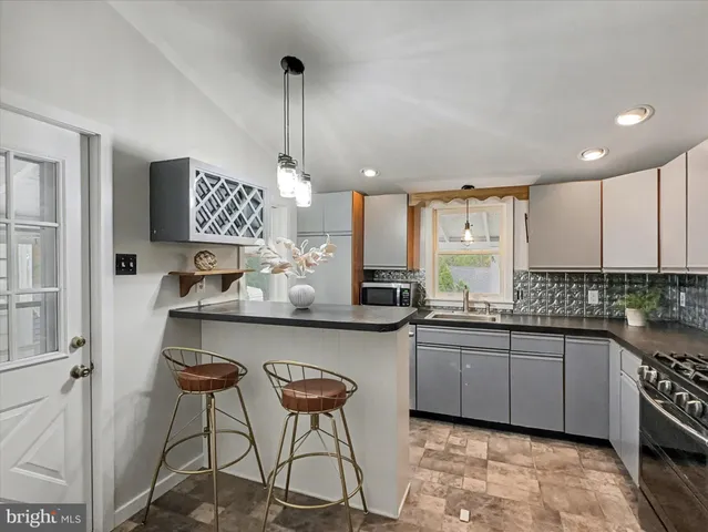 a kitchen with stainless steel appliances a sink a stove a refrigerator and cabinets